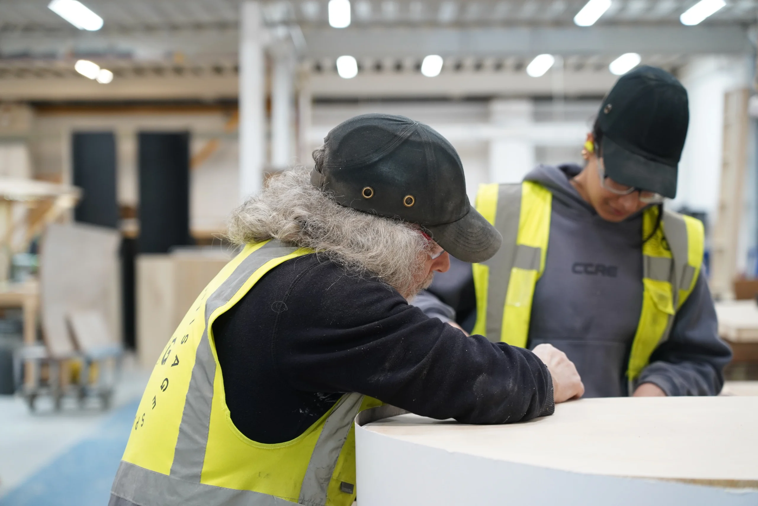 male and female in workshop on joinery bench in manufacturing stage of the design and build process
